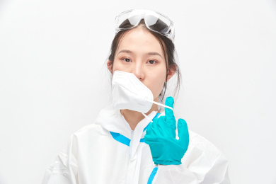 穿白色防护服佩戴护目镜口罩的女性医疗人员