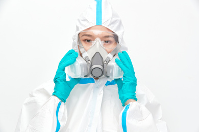 穿白色防护服佩戴护目镜口罩的女性医疗人员