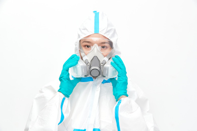 穿白色防护服佩戴护目镜口罩的女性医疗人员