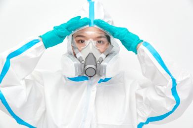 穿白色防护服佩戴护目镜口罩的女性医疗人员