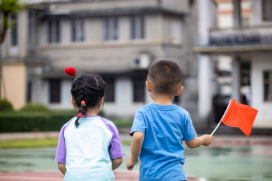 拿着红色小旗玩耍的小朋友