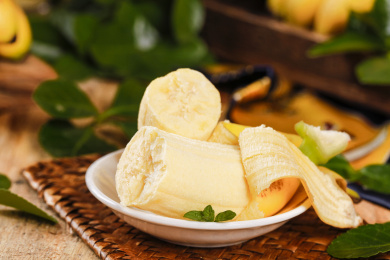 藤编垫上盘子里放着一根剥皮掰段的小香蕉