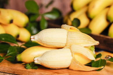 木底上放着一根金香蕉和两根剥开的小香蕉