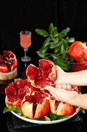 手上拿着一个掰开的突尼斯软籽石榴