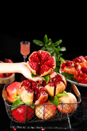 手上拿着一个掰开的突尼斯软籽石榴