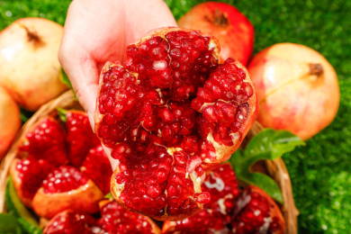 手上拿着一个掰开的突尼斯软籽石榴