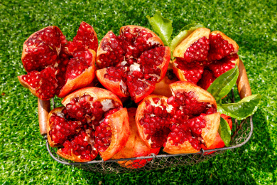 绿色草坪上放着一筐剥开的突尼斯石榴