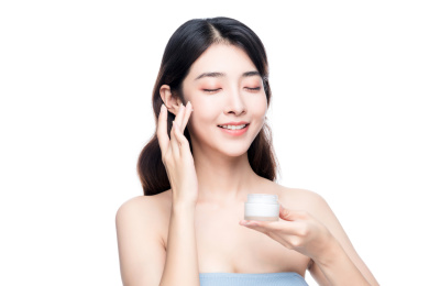 漂亮的亚洲美女抹面霜白色背景半身肖像
