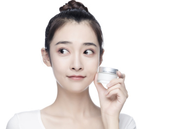 漂亮的亚洲美女抹面霜白色背景半身肖像