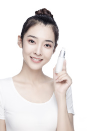 手拿护肤乳的亚洲美女白色背景半身肖像