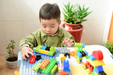 可爱的亚洲小男孩正在玩着创意积木游戏