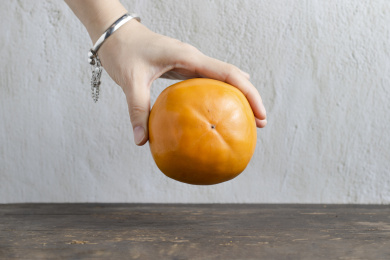 一个手拿着的脆柿子