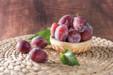 竹编簸箕里的水果西梅