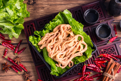 传统中式背景中装在黑色盘子中的鸭肠