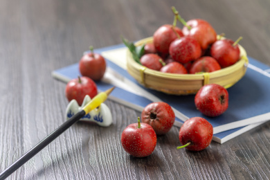 山楂红果摆放在放有线装书的木桌面上