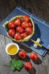 山楂红果摆放在放有线装书的木桌面上