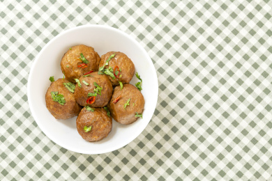 一碗美味的猪肉丸子摆放在格子桌布上