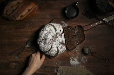 放在黑胡桃木砧板上的欧包和切片