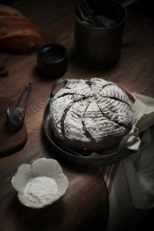 放在深色铁盘里的黑加仑可可面包欧包