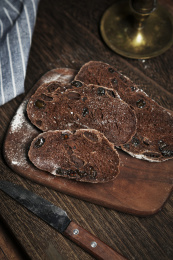 放在黑胡桃木砧板上的欧包切片