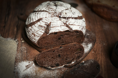 放在黑胡桃木砧板上的欧包和切片