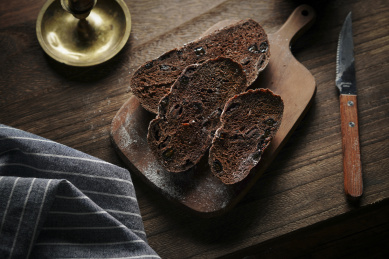 放在黑胡桃木砧板上的欧包切片