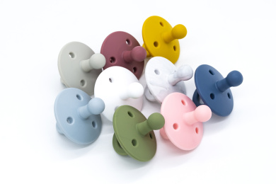 白色背景上的婴儿用各色硅胶奶嘴