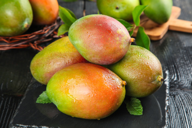 黑底上放着一堆新鲜凯特芒果