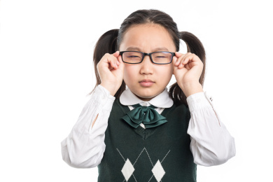 近视的小学生眯着眼带眼镜