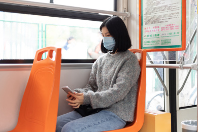 女孩戴着口罩乘坐公交车