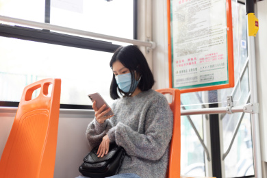 女孩戴着口罩乘坐公交车