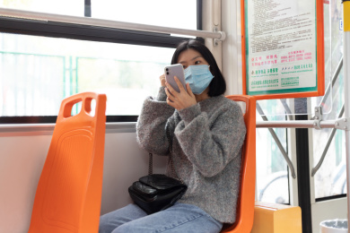 女孩戴着口罩乘坐公交车