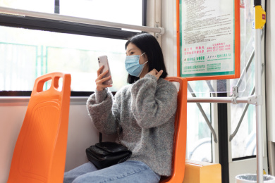 女孩戴着口罩乘坐公交车