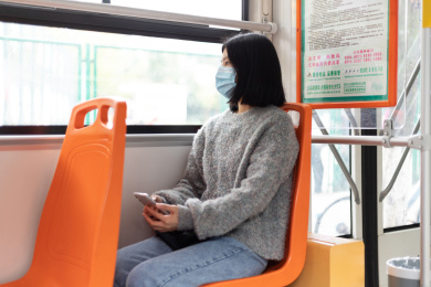 女孩戴着口罩乘坐公交车