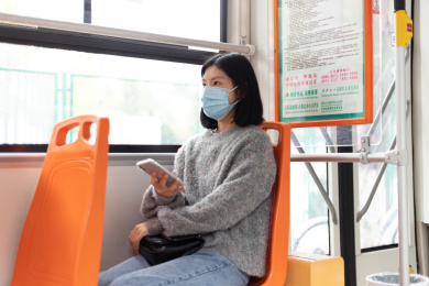 女孩戴着口罩乘坐公交车