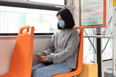 女孩戴着口罩乘坐公交车