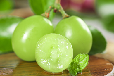 木板上放着两个完整的香印青提和半边青葡萄