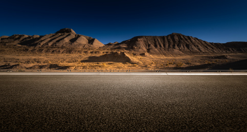 远处高山,荒无人烟荒漠边上的高速公路
