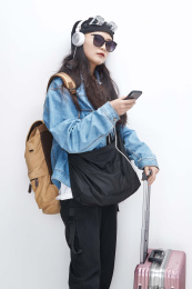 手里拿着手机准备出发的美丽东方女孩