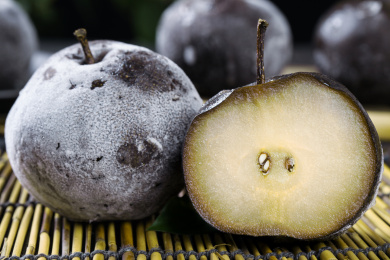 竹底上放着一个切面冻梨和完整的冻秋梨