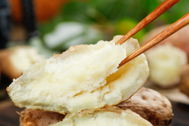 一堆蒸熟的白心蜜薯和筷子夹着蜜薯