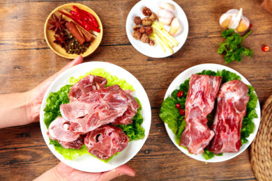 木底上放着一盘鲜羊骨和手上端着一盘羊蝎子