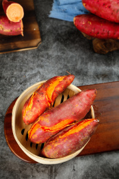 深木板上放着一笼蒸熟的六鳌红蜜薯