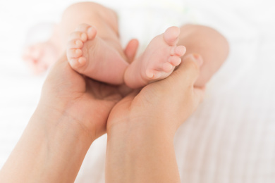 妈妈用手托住婴儿胖嘟嘟的小脚丫