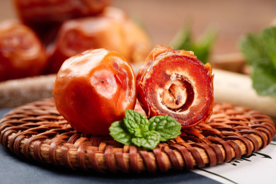 滕编垫上放着一个完整的黄椰枣和半边椰枣