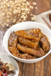 一碗红烧牛筋炖牛筋摆放在木桌面上