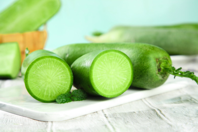 白石板上放着一根沙窝萝卜和两半节水果萝卜