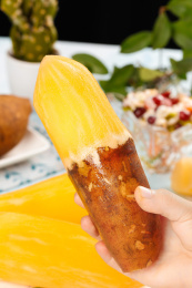 手上拿着一个削开半节皮的红泥沙雪莲果