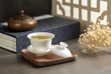 盖碗茶三才杯摆放在窗棂影木桌面上