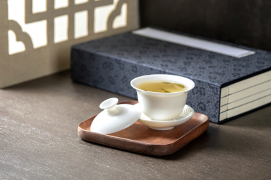 盖碗茶三才杯摆放在窗棂影木桌面上